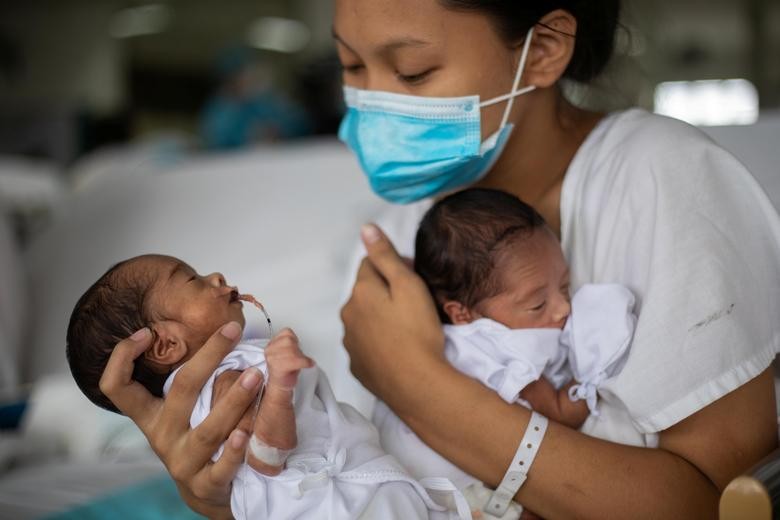 A mother wearing a mask nestles her newborn premature babies inside the maternity ward of the government-run Dr. Jose Fabella Memorial Hospital in Manila, Philippines, September 18, 2020. . REUTERS/Eloisa Lopez